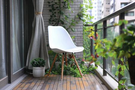 A white chair and a potted plant are placed on a balcony overlooking a grassy yard. The wooden fixture complements the interior design, providing a cozy spot to relax in the shadeの素材