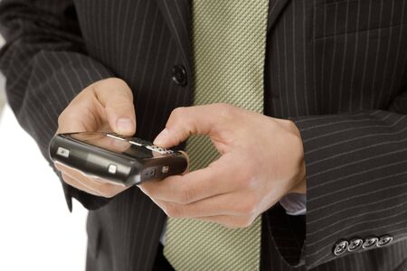 Businessman uses his thumbs to text on a mobile deviceの写真素材
