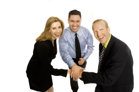 Three business people gesture teamwork with their hands