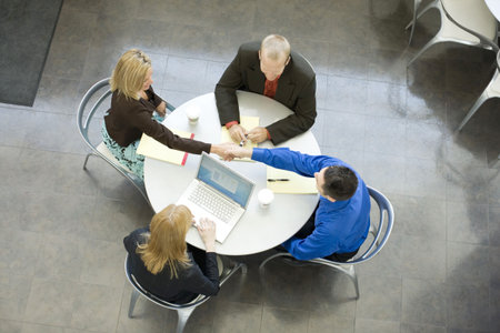 Four business people sit and talk at a table