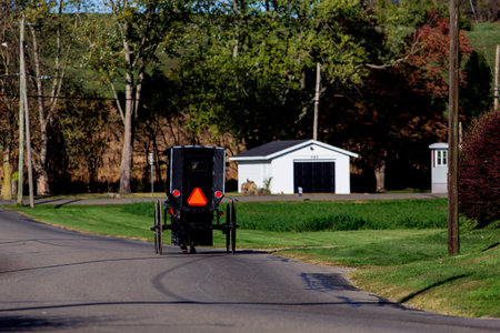 Amish Buggy Moving Along a Town Street, Sugarcreek, Ohioの写真素材