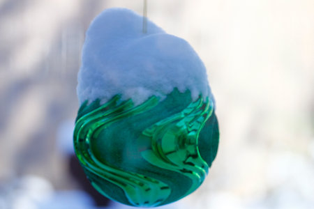 Large, Snow-Covered Christmas Ornament on a Outdoor Treeの写真素材
