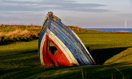 Part of an old Lifeboat placed in the middle of a park with a seated bench for walkers to rest near Bridlingtonのeditorial素材