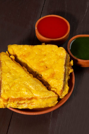 Indian Fried Snack Bread Pakora or Bread Bhaji Served with Tomato Ketchup, Green Chutney it is Made...