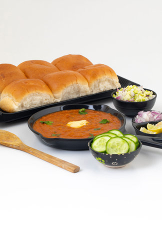 Pav Bhaji is a Indian Traditional Popular Street Fast Food. Thick And Spicy Vegetable Curry Served With a Soft Bread Roll/Bun Paav And Butterの写真素材