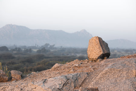 Balancing stone on mountains with skyの写真素材