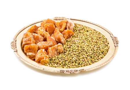 Group of jaggery with Coriander Seeds also Know as Gur, Goor or Gud isolated on White Background