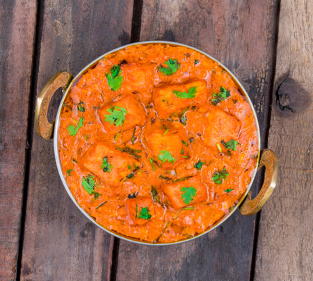 Indian Delicious Cuisine Paneer Tikka Masala Also Called Paneer Butter Masala is an Indian Dish of Marinated Paneer Cheese Served in a Spiced Gravy on Wooden Backgroundの写真素材