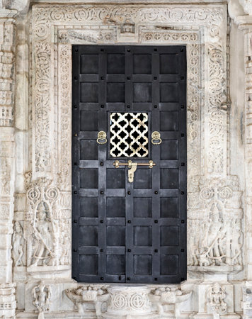 The Closed Wooden Door of An Ancient Jainism Temple in Ranakpur Village in Rajasthan, Indiaの写真素材