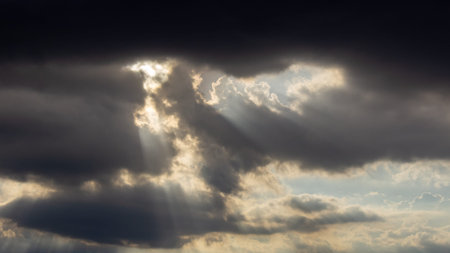 Dramatic sky with dark clouds and sun rays. Nature background