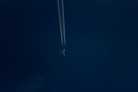 Airplane in the blue sky with contrails, close-upの写真素材