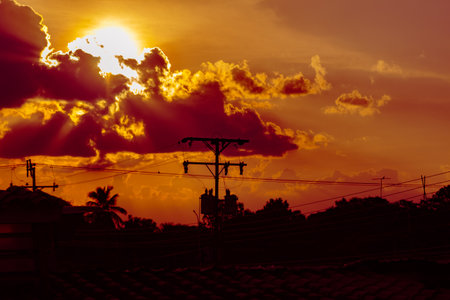 Silhouette of streetlight at sunset with clouds and sky.の写真素材