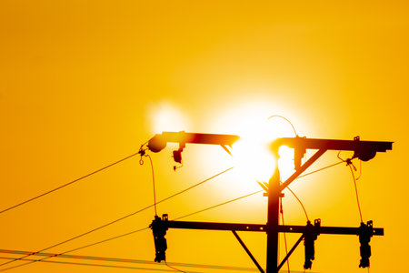 Silhouette of high voltage electric pole with sun light background.の写真素材