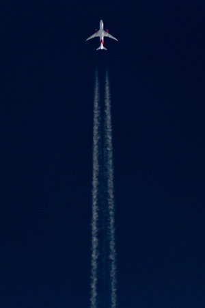 Airplane in the sky with contrail, closeup of photo