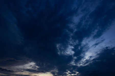 Dramatic sky with dark clouds at sunset. Natural background.の写真素材