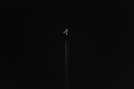 Plane flying in the night sky. Black and white photos.の写真素材