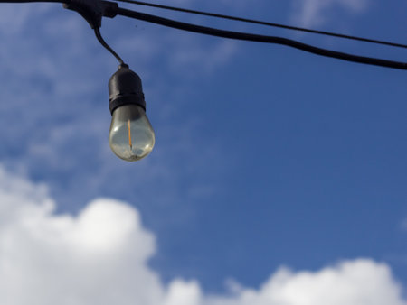 light bulb on electric pole with blue sky and white clouds background.の写真素材