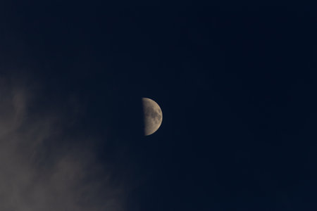 Moon in the dark sky with clouds, closeup of photo.の写真素材