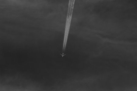 Airplane in the cloudy sky. Black and white photo with copy space.の写真素材
