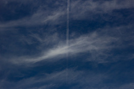 blue sky with white clouds and plane trailbe used as backgroundの写真素材