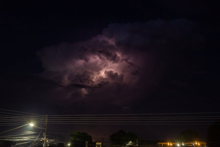 Lightning strike in the night sky with street light and cloud.