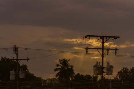 Silhouette of electricity post with sunset sky background, Thailand.