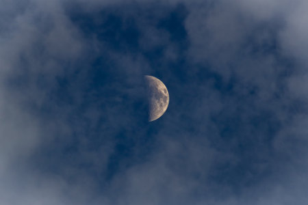 Moon in the blue sky with white clouds closeup. The lunar eclipse.の写真素材