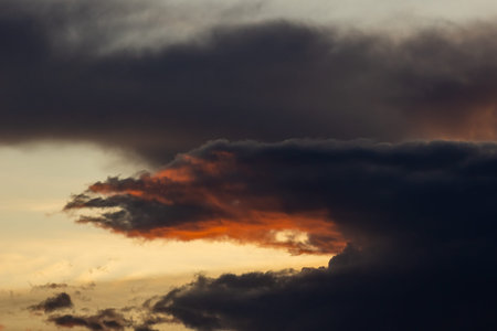 Dramatic sky with dark clouds at sunset. Natural background.