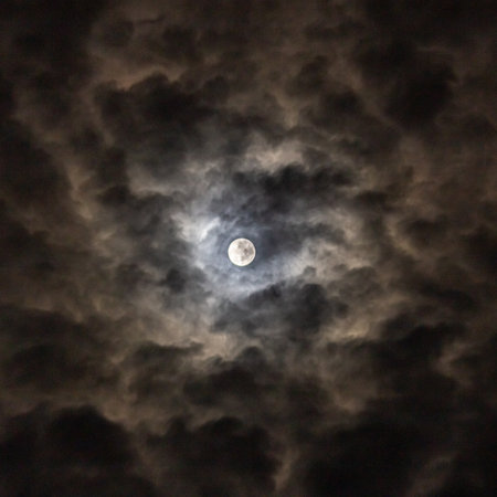 Full moon in the night sky with dark clouds, closeup of photoの写真素材