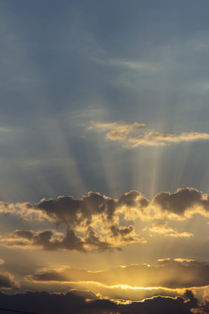 Sunset sky with clouds and sunbeams. Natural background.
