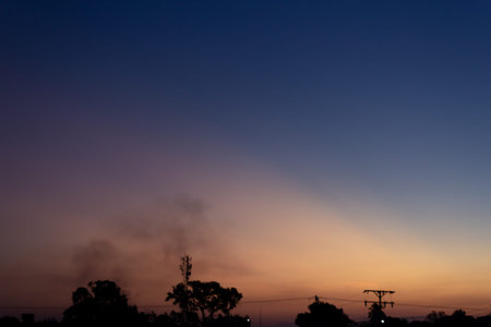 Silhouette of smoke from a fire in the evening with blue sky
