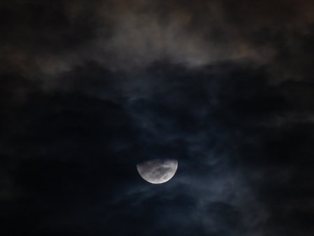 Moon in the night sky with clouds as a background, closeupの写真素材