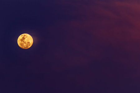 Super full moon in the night sky with clouds, natural background.