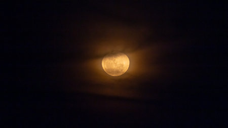 Full moon in the night sky with clouds, as a background.の写真素材