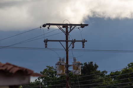 Electricity post with cloudy sky in the background. Selective focus.