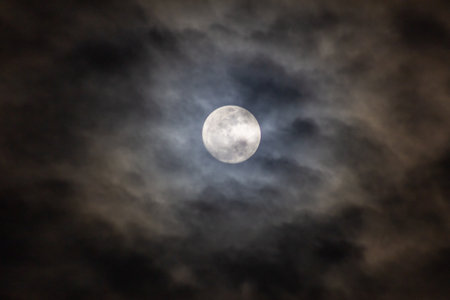 Full moon in the night sky with dark clouds, nature background.の写真素材