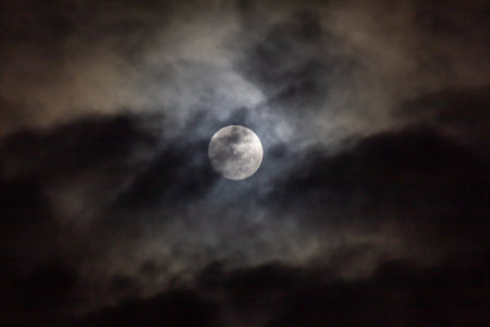 Full moon in the dark night sky with clouds. Space background.の写真素材