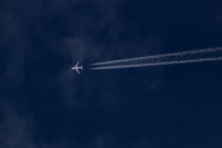airplane in the blue sky with white clouds, closeup of photoの写真素材