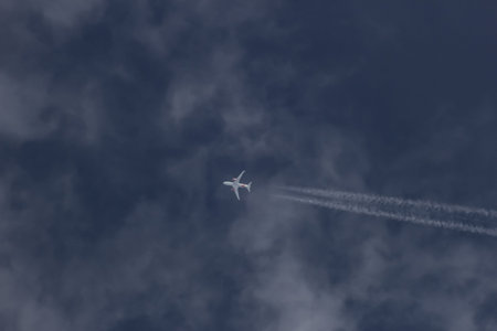 Airplane flying in the blue sky with white clouds, closeup of photo