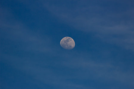 Moon in the blue sky with clouds background. Close-up.の写真素材