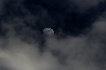 The moon in the dark sky in the clouds as a background.の写真素材