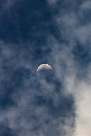 Moon in the clouds on a sunny day, closeup of photo