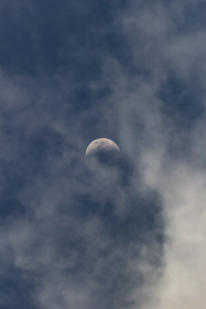 Moon and clouds in the blue sky, closeup of photo.の写真素材