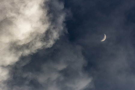 The moon and the clouds in the sky in the early morning.の写真素材