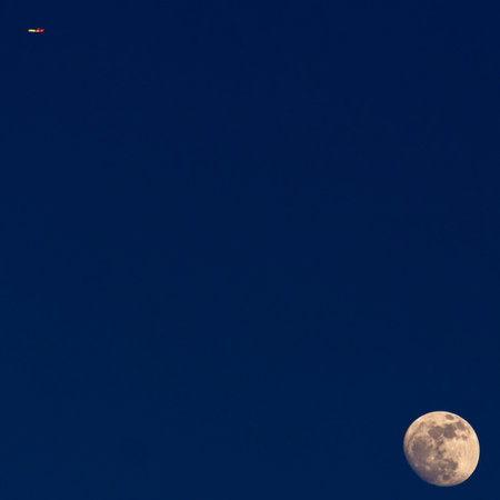 Super moon and red plane in the night sky, natural background.