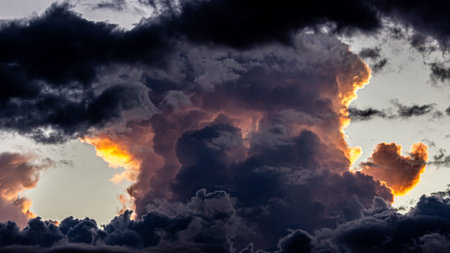 Dramatic sunset sky with dark clouds and sun. Panorama