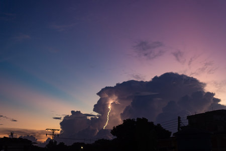 Lightning strike in the sky at sunset. Thunderstorm over the city.