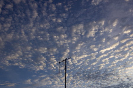 Blue sky with white clouds and a TV antenna. Abstract background.の写真素材