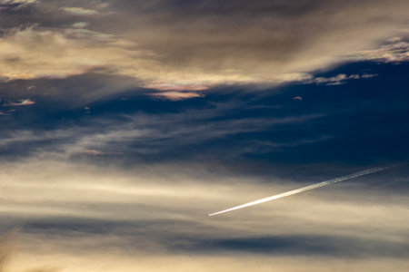 Airplane in the blue sky with clouds at sunset. Travel backgroundの写真素材