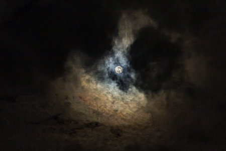 The moon in the night sky in clouds close-up.